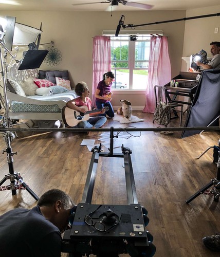 set photo of filming a girl playing the guitar with her dog