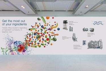 White room with wall featuring Alfa Laval logo and headline "Get the most out of your ingredients" with various fruits and alfa laval equipment