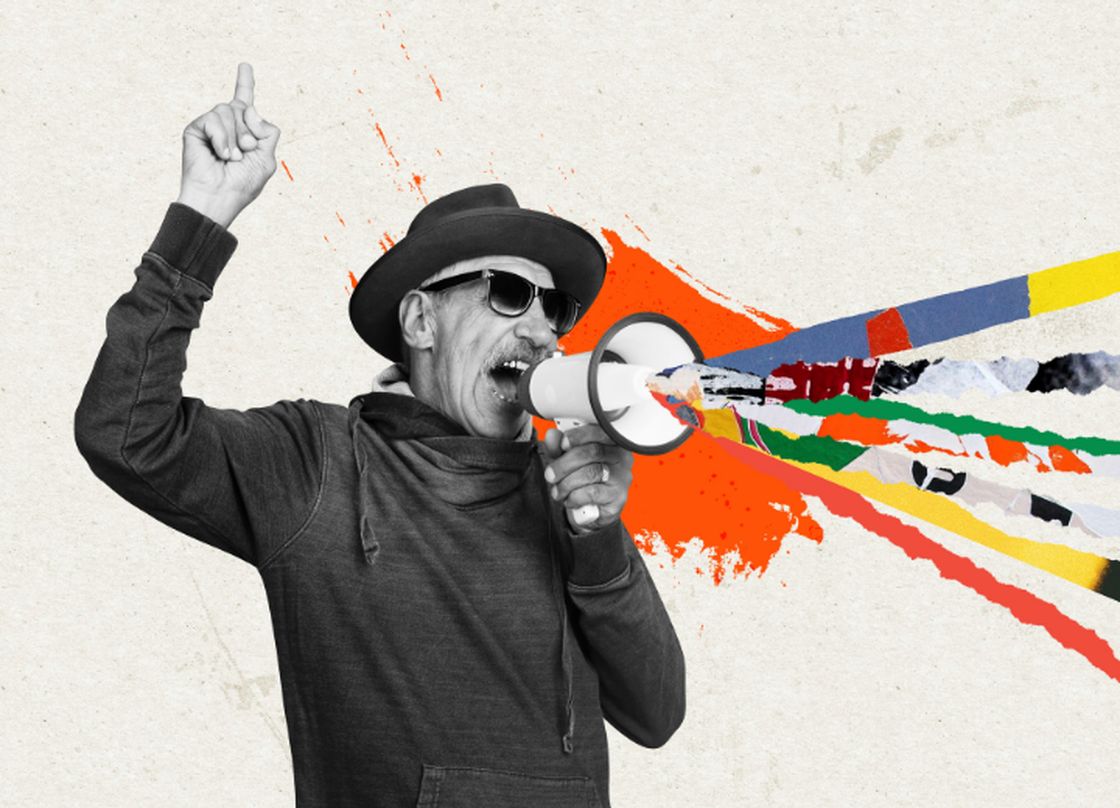 man with glasses and a fedora shouting into a megaphone. burst of color coming from megaphone