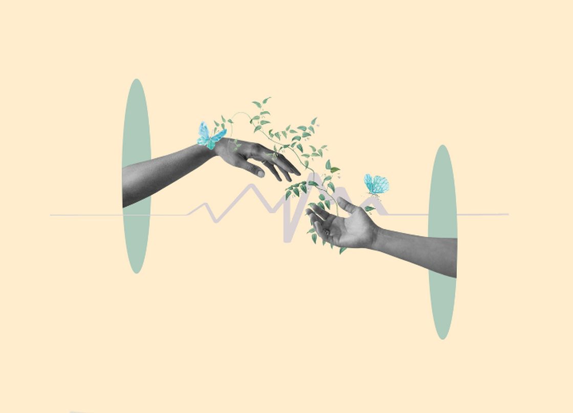 two hands meeting with growing flowers around them