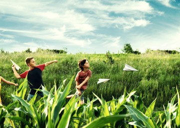 kids throwing paper airplanes