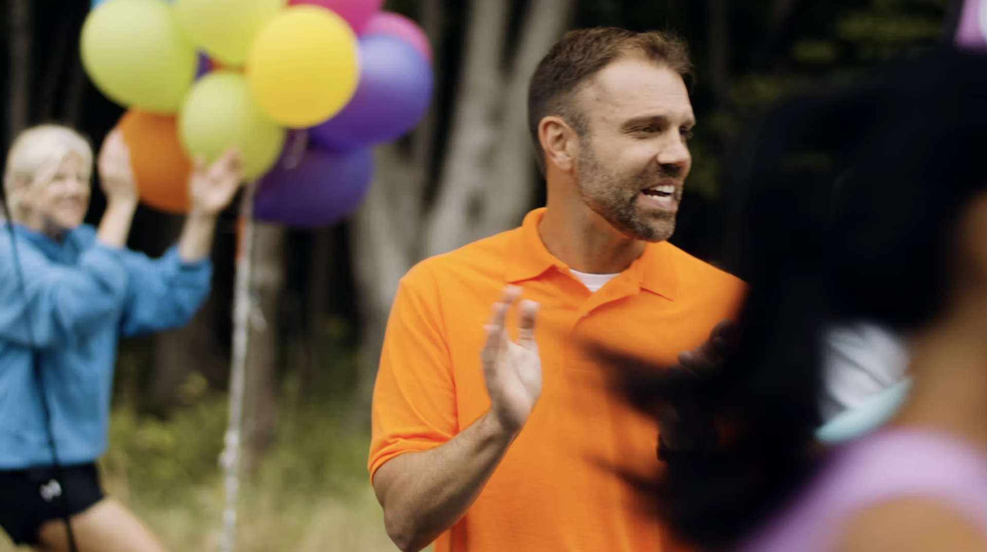 video still from the art of storytelling video showing a man in orange clapping