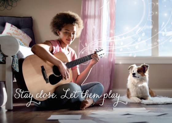 Girl playing guitar in bedroom with cute dog watching, musical notes in the air