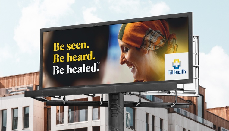 A billboard created by core with a woman smiling and the tagline"Be seen. Be heard. Be healed."