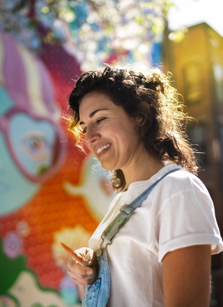 A photo of a woman at a colorful Cincinnati mural.
