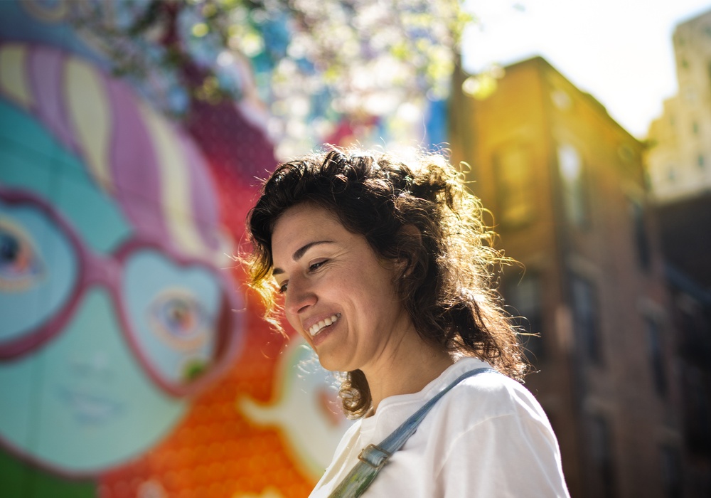 A photo of a woman at a colorful Cincinnati mural.