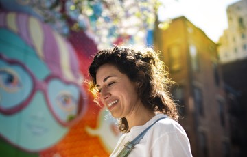 A photo of a woman at a colorful Cincinnati mural.