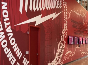 Milwaukee tool branding on the facade of a steel wall with a door.